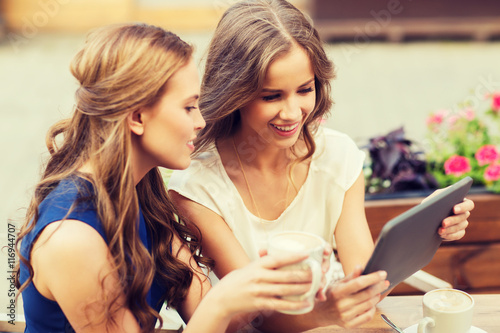 young women with tablet pc and coffee at cafe