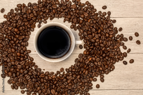 Coffee cup and coffee beans on wooden background