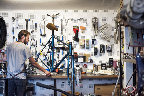 A man working in a bicycle repair shop. 