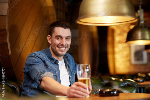 happy man drinking draft beer at bar or pub