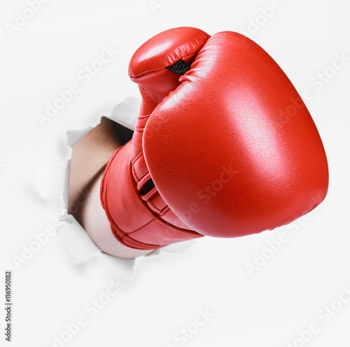 Valokuva Hand in a red boxing glove broke through the paper wall