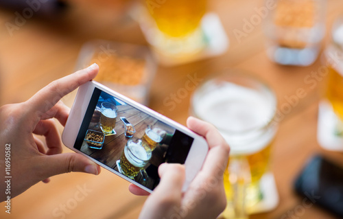 close up of hands with smartphone picturing beer