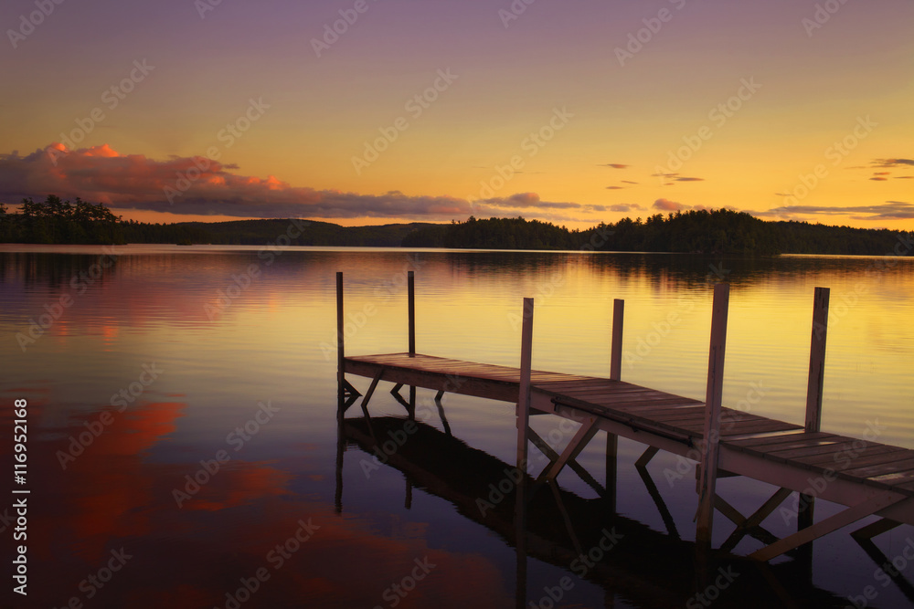 old pier in a lake at the sunset in maine - united states of america