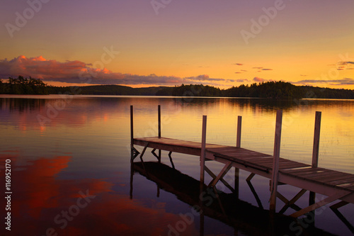 old pier in a lake at the sunset in maine - united states of america