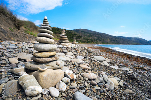 The three pyramids of sea pebbles on the beach .