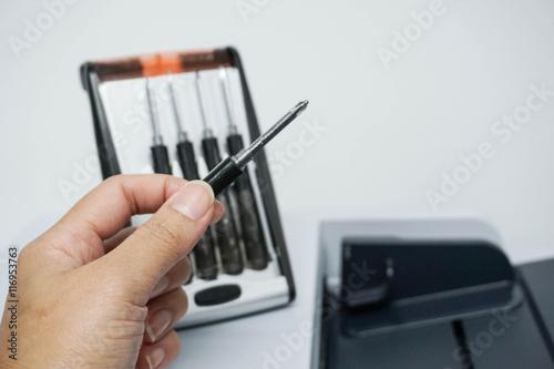 Hold a screwdriver for fixing printer