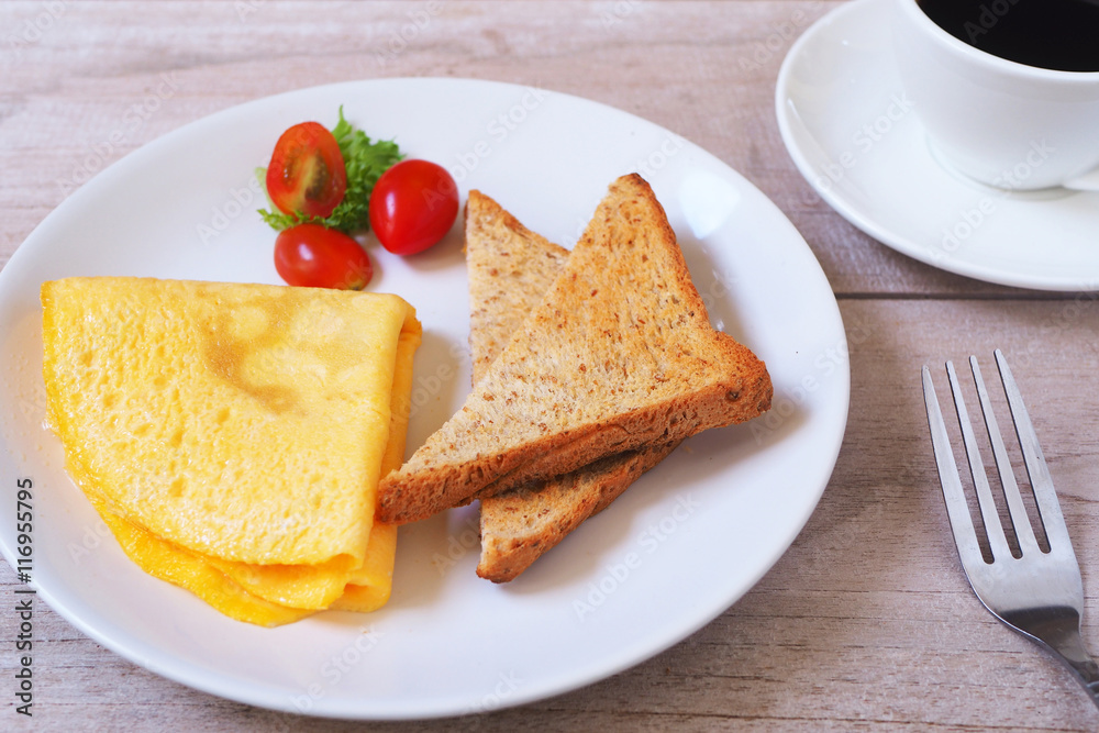 Omelette with toast and vegetable for breakfast on a wooden table. Omelette with toast and vegetable for breakfast on a wooden table.