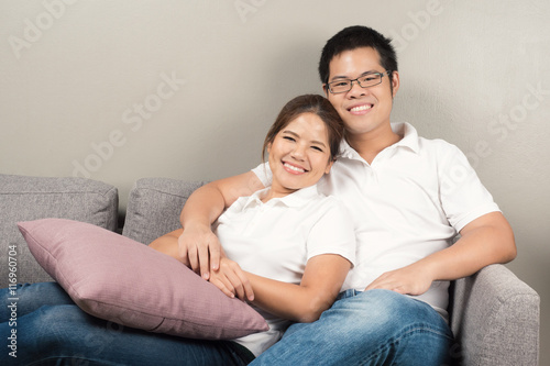 asian couple relaxing on couch © phonlamaiphoto