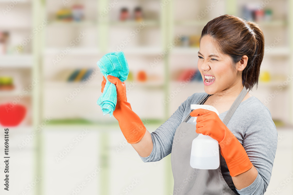 asian housewife holding spray bottle and rag fighting with dirty
