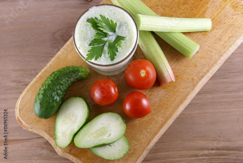 Useful summer snack: vegetables and yogurt sauce with herbs. Against the background of a rustic wooden table