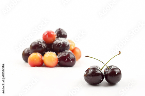cherries sprinkled with coconut on white background