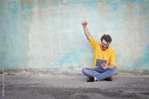 Jubilant man holding a tablet