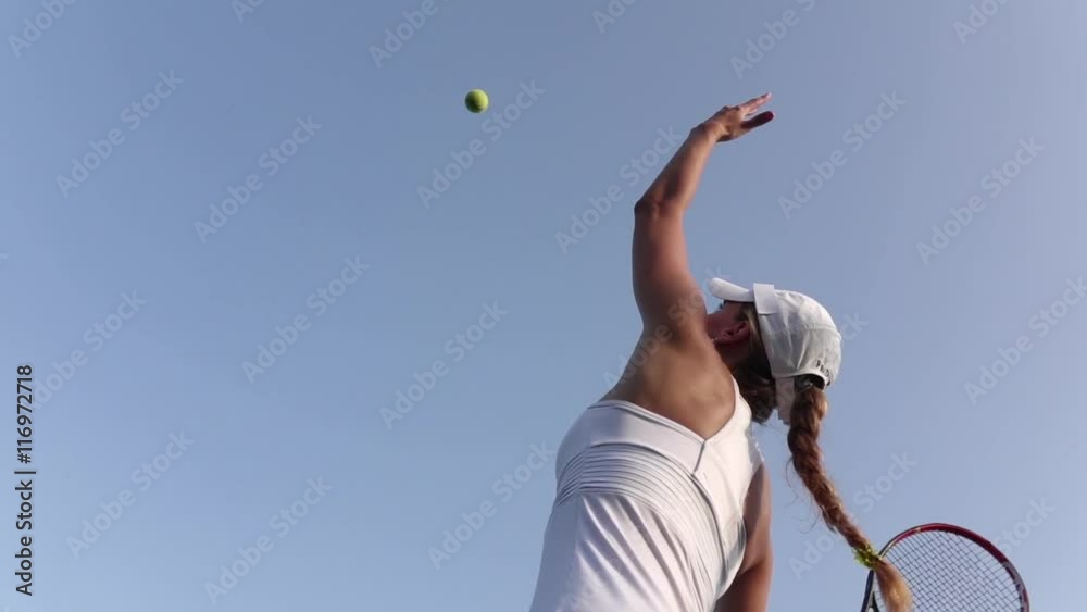 Girl serving tennis ball. Tennis player. Slow motion