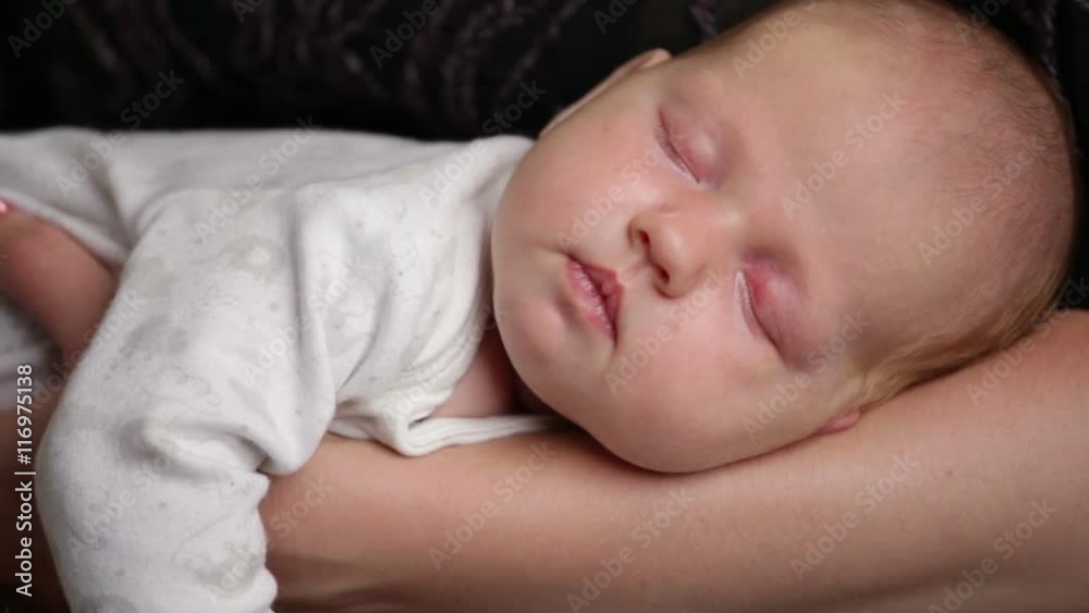 Close up newborn baby is sleeping on mother's hands Close up newborn baby is sleeping on mother's hands