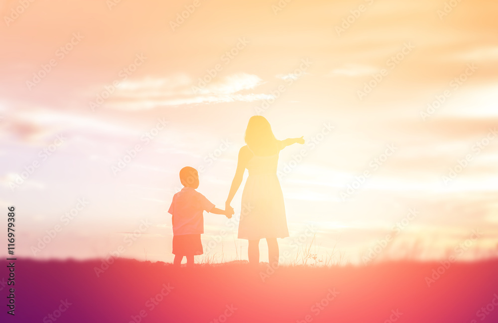 Fototapeta premium Mother encouraged her son outdoors at sunset, silhouette concept