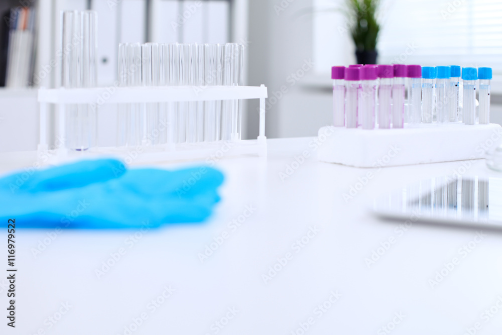 Research laboratory working space. Test tubes and tablet PC are lying at the table. Medical equipment. Blood test Research laboratory working space. Test tubes and tablet PC are lying at the table. Medical equipment. Blood test