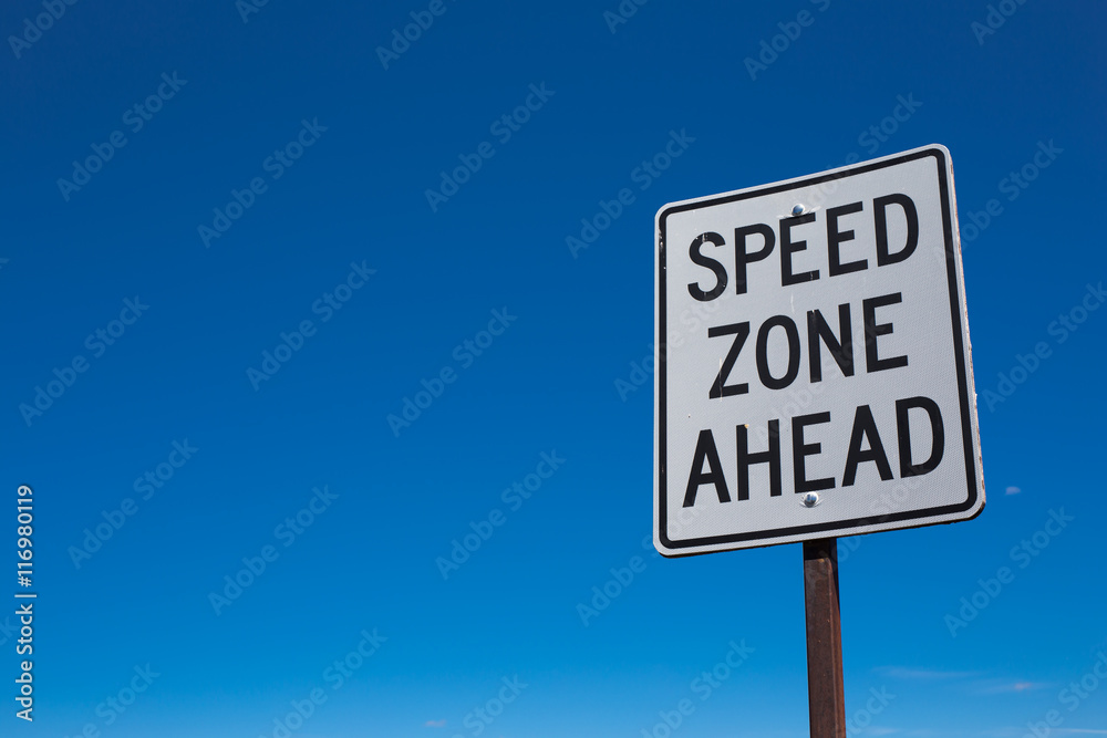 White speed zone limit sign with blue sky background