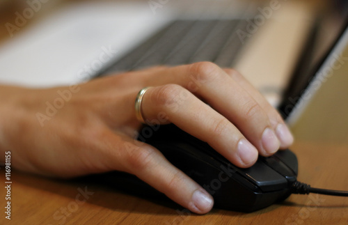 Woman’s hand on the computer mouse at works