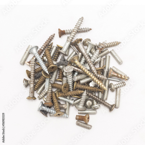 Closeup of a pile of old rusty screws isolated on white background, top view