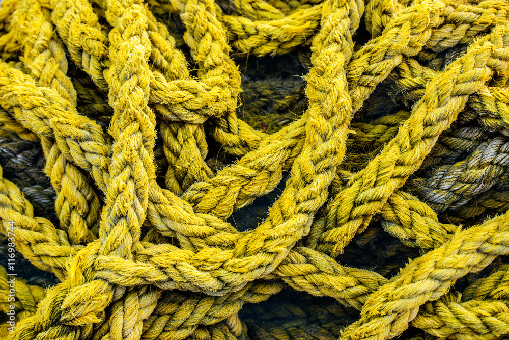 Old yellow boat rope background. Strong vintage rope for mooring the ship at the berth.