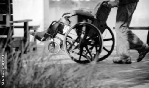 Elderly old woman on wheelchair black and white blur.