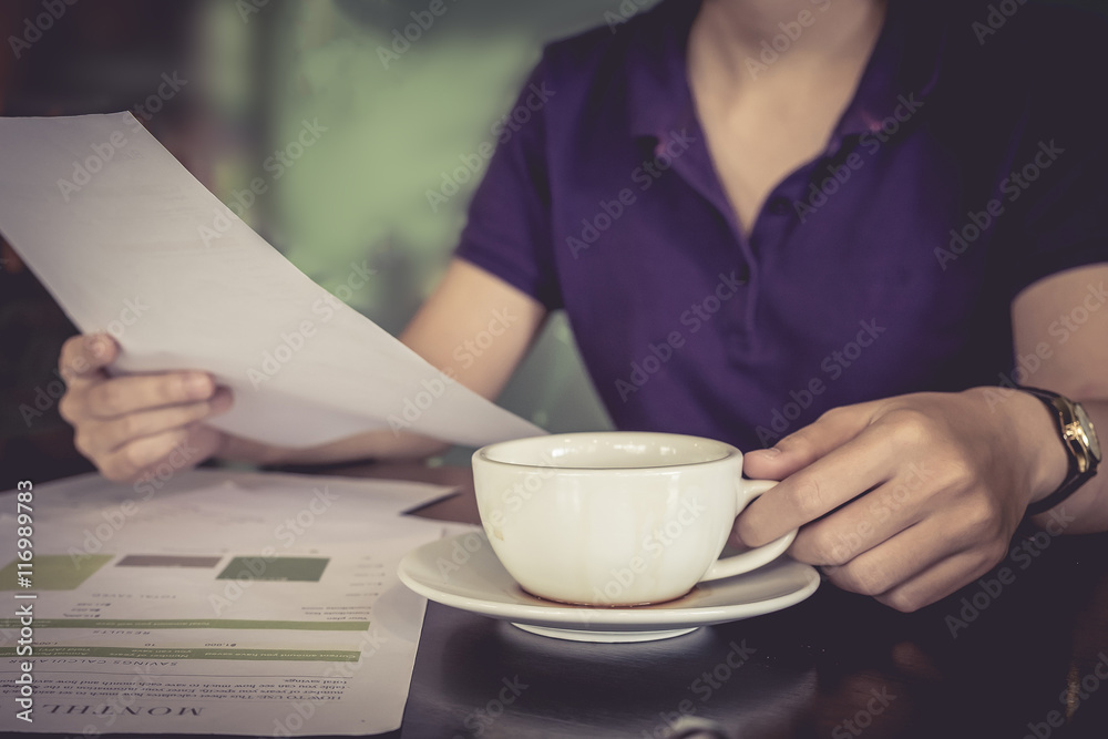 close up hand of business women holding cup of coffee and paper close up hand of business women holding cup of coffee and paper