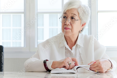 Senior woman reading a book at home