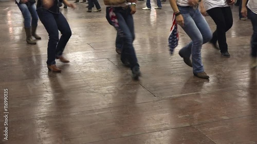 Western dancers dancing a choreography at a country festival, wearing cowboy boots, jeans and USA flag. Learning line dance. Music, traditions and fun