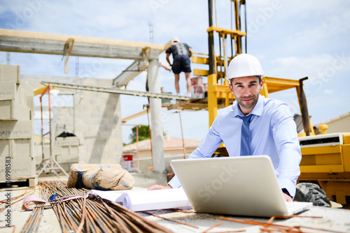 portrait of handsome young man architect on a building industry construction site