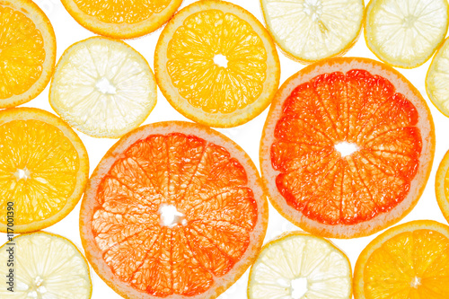 Lemon, grapefruit and orange cut by segments located close photographed against the light isolated on white background