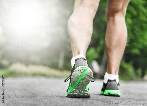 Athlete runner feet running on road.