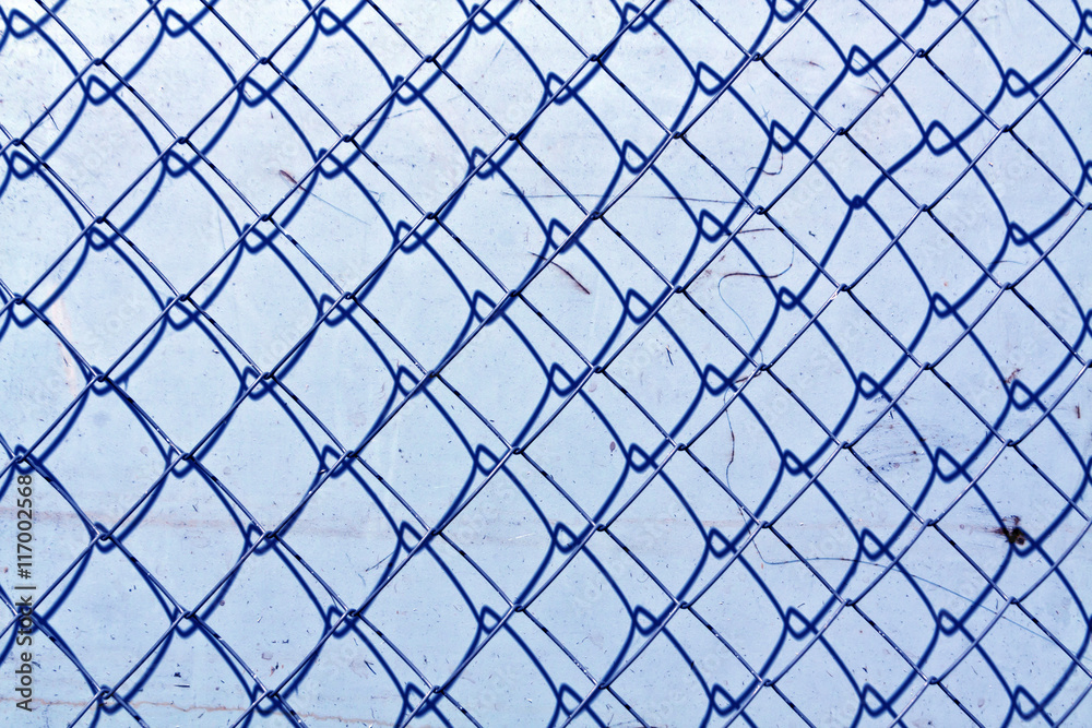 abstract chain link fence texture against grungy color wall. abstract chain link fence texture against grungy color wall.