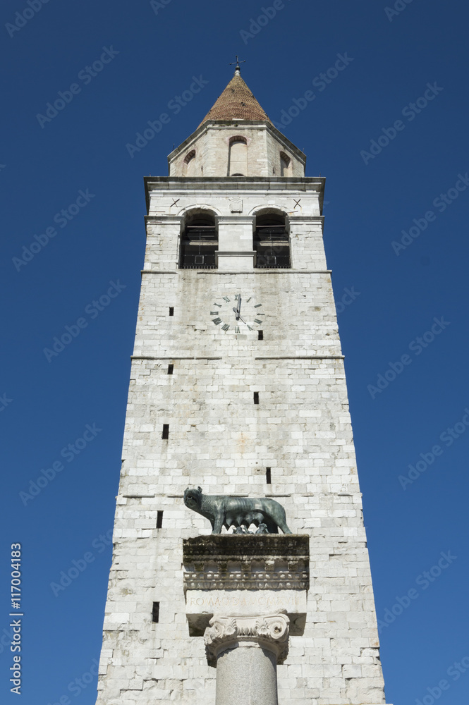 Church steeple in front of capitoline wolf column