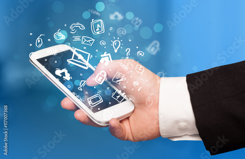 Hand holding smartphone with media icons and symbol