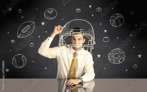 Businessman drawing helmet and sport balls