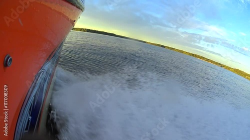 camera moving forward by board of the speed boat, water wave splashing to camera lens, beautiful sunset on horizon line photo