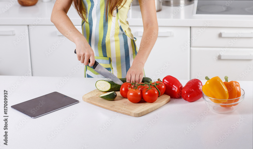 woman cuts vegetables in the kitchen woman cuts vegetables in the kitchen