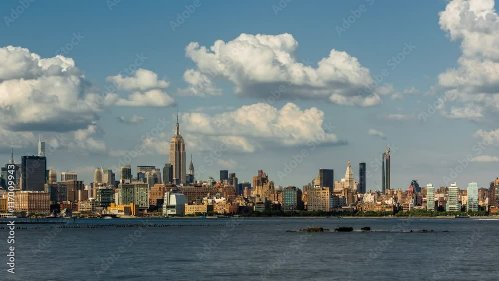 Cityscape time lapse of a summer afternoon in New York City, Manhattan. View of Midtown West skyscrapers, West Village and Hudson River with passing clouds Cityscape time lapse of a summer afternoon in New York City, Manhattan. View of Midtown West skyscrapers, West Village and Hudson River with passing clouds