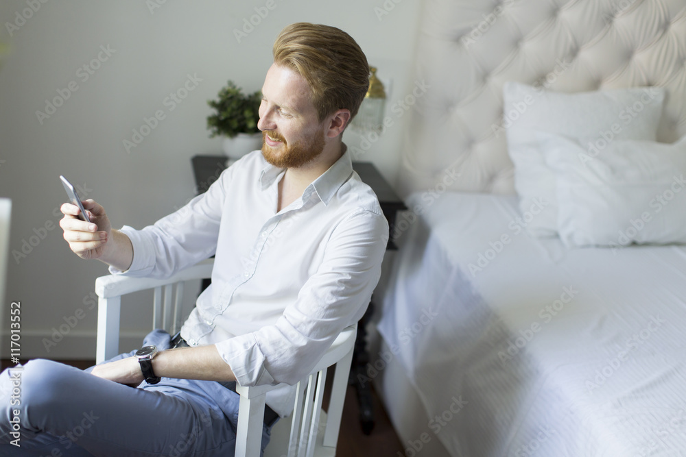 Obraz premium Redhair man with phone in the room