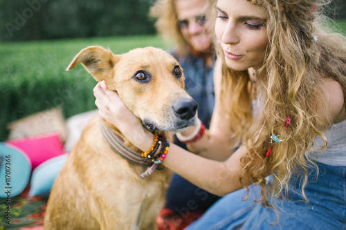 Young beautiful hippie couple with dog in nature
