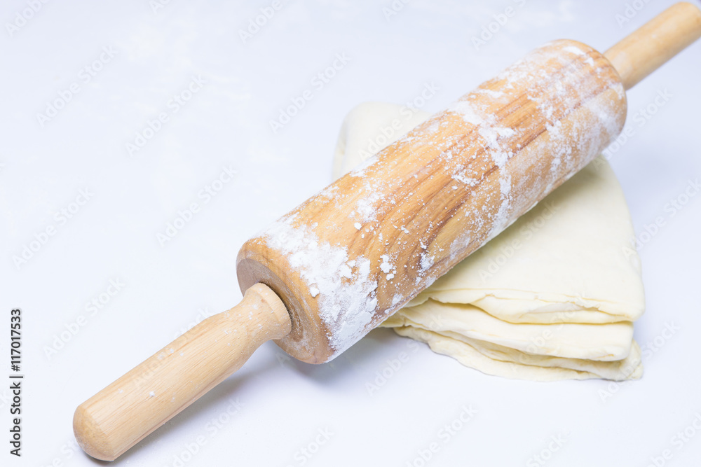 Flattening dough with a wooden rolling pin