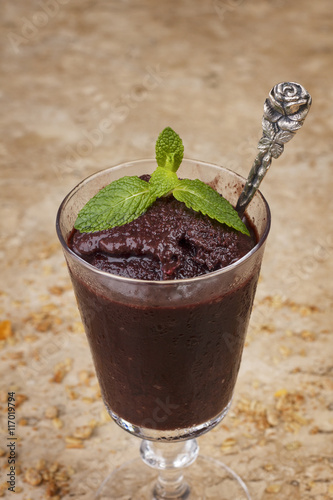 Acai pulp in glass with fresh mint and muesli