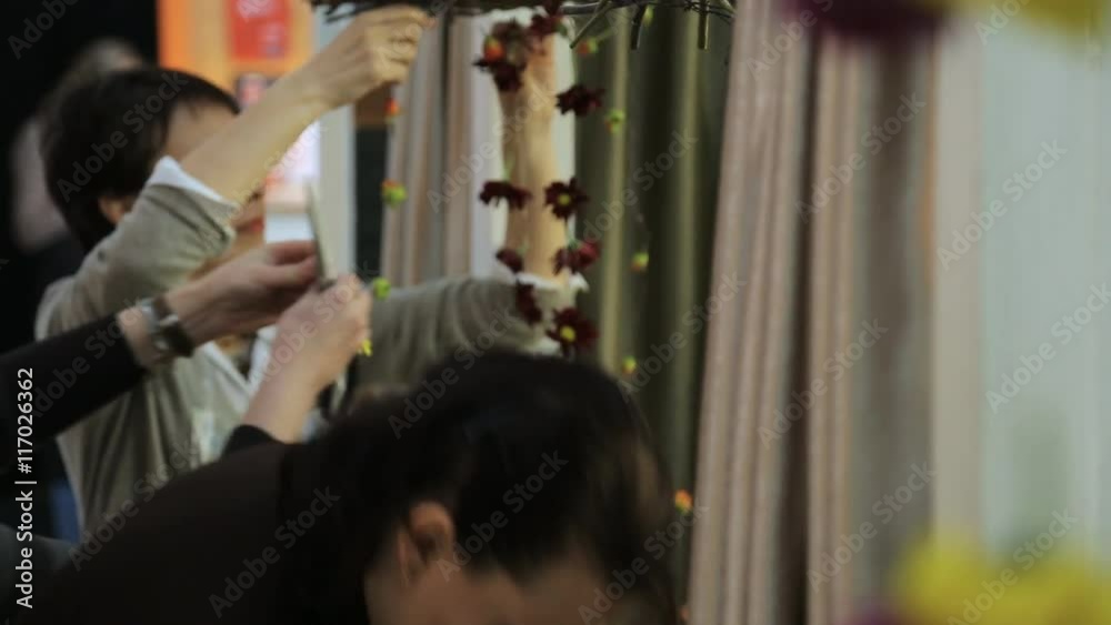 Group of women decorate interior of room with garlands made from flowers. Group of women decorate interior of room with garlands made from flowers.