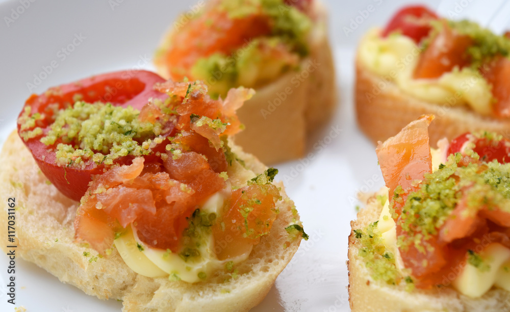 Homemade canapès with salmon, tomato and bread. Homemade canapès with salmon, tomato and bread.