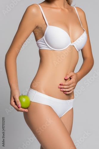 Beautiful woman body and green apple. Conceptual image of dieting healthy lifestyle