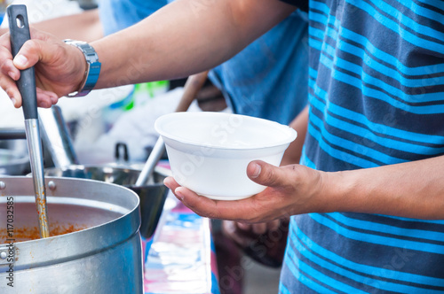 hand holding Spoon food in the foam tray ,streetfood