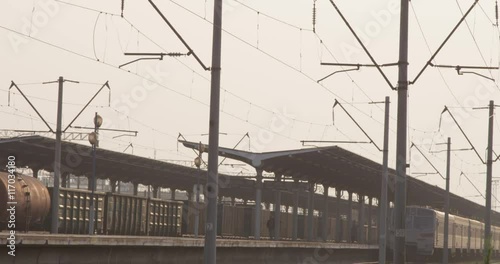 Train leaving station with people walkng during sunset photo