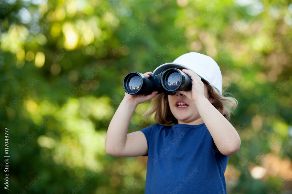 Little cute girl in the park looking by binoculars Little cute girl in the park looking by binoculars