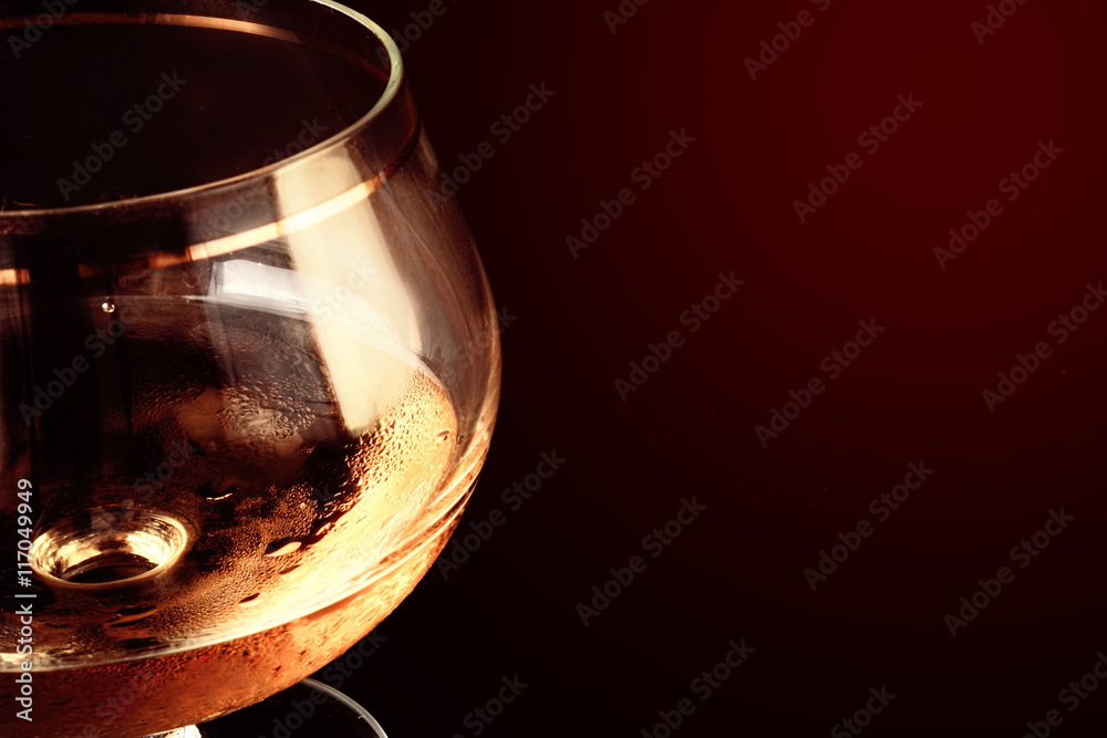 Close up of alcohol in a glass glass against a dark background.