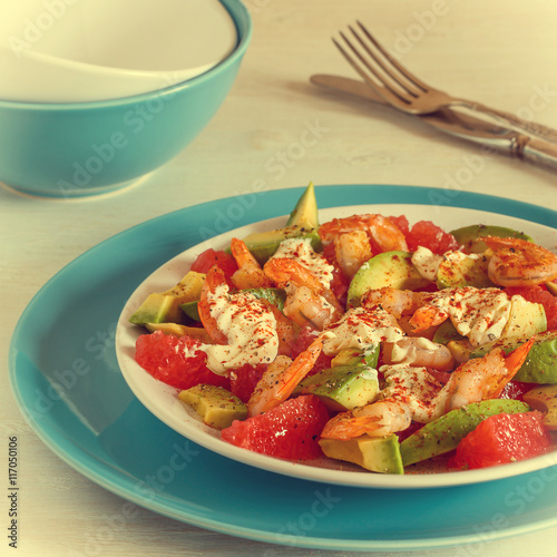 Salad - a mix of avocado, shrimp and grapefruit, selective focus. Instagram style.